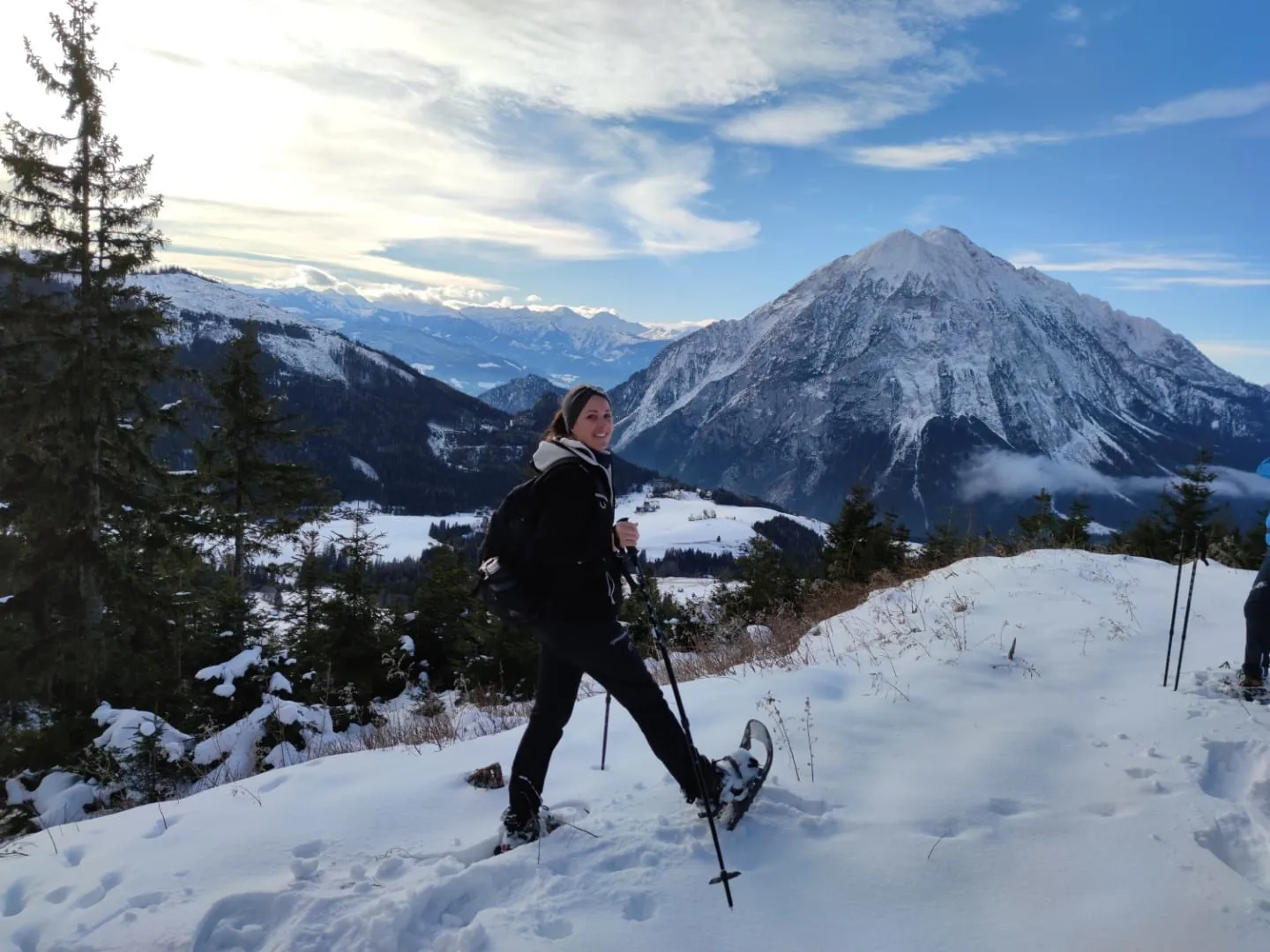 Jennifer mit Schneeschuhen im Tiefschnee, im Hintergrund der Grimming