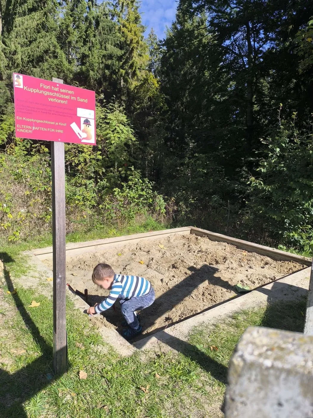 Kind sucht in der Sandkiste nach dem Kupplungsschlüssel