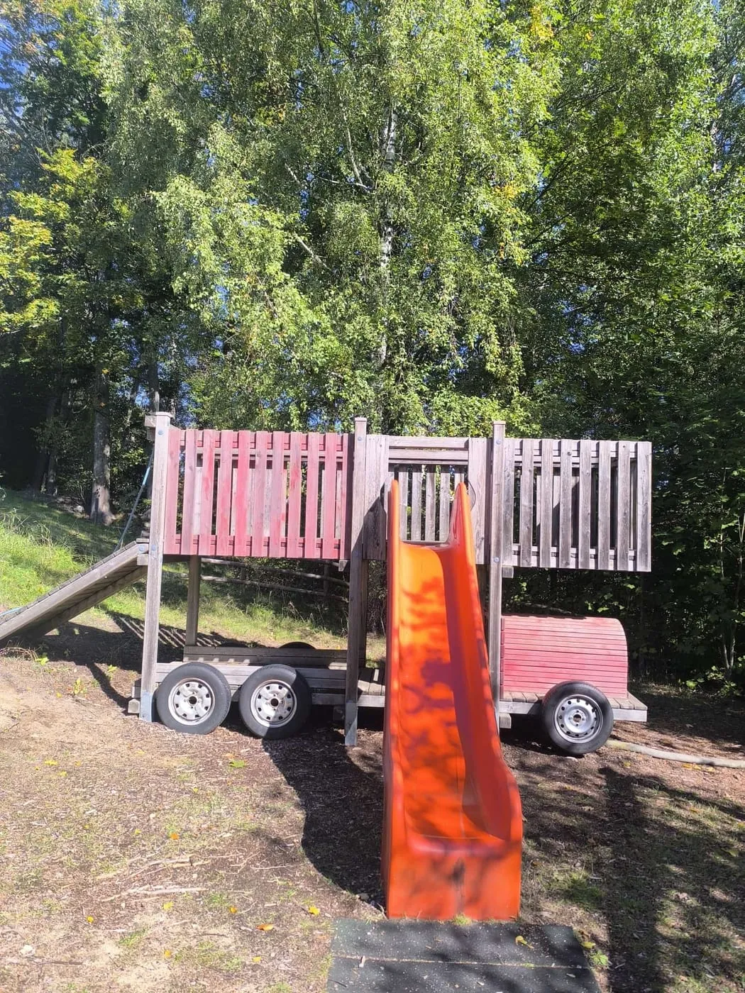 Spielplatz mit einem Feuerwehrauto aus Holz und Rutsche