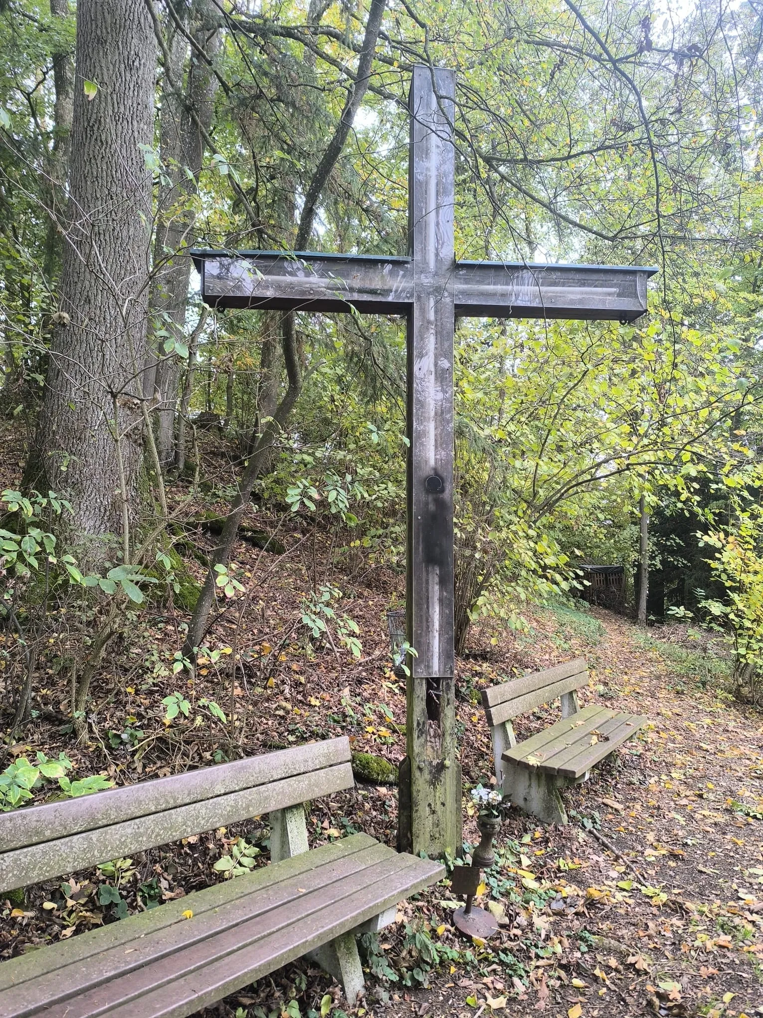 Das Gipfelkreuz aus der Nähe, daneben eine Holzbank