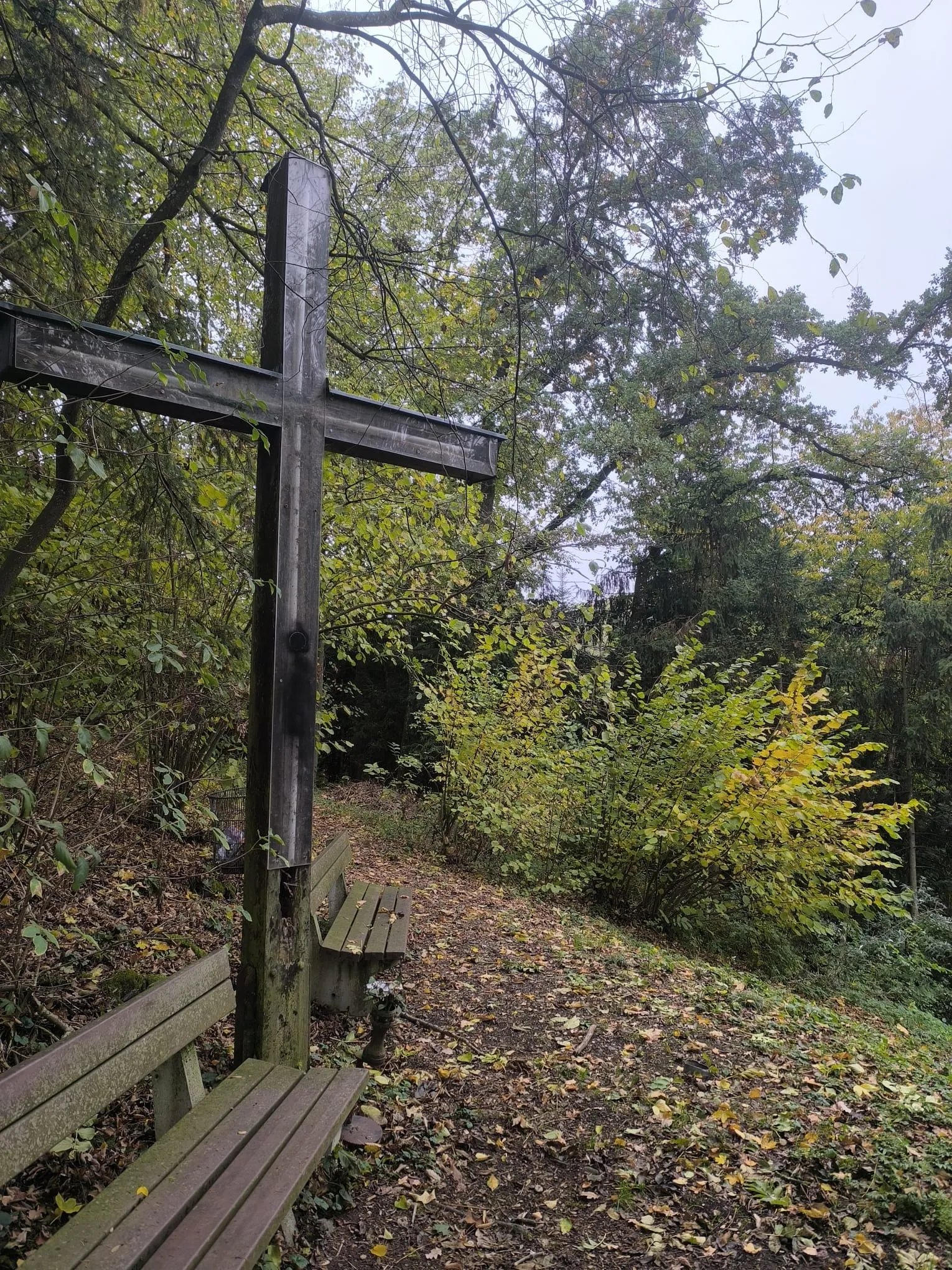 Das große Holzkreuz am Kreuzberg in Kremsmünster, davor eine Bank